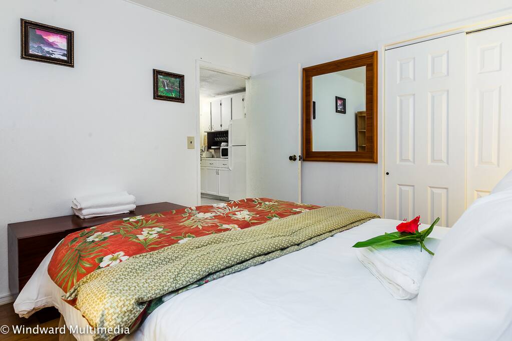 Bedroom with queen bed and window AC unit