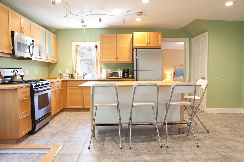 Kitchen with dishwasher, coffee maker, toaster oven, pots, pans, flatware, cooking utensils, etc.