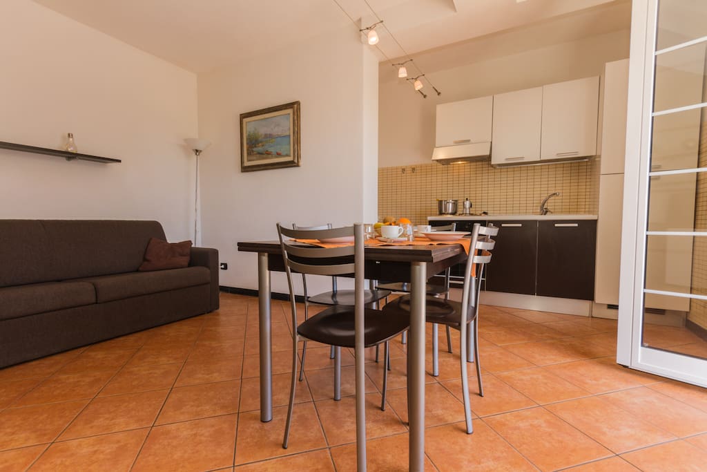 Kitchen and living room with flat screen TV dining table and sofa