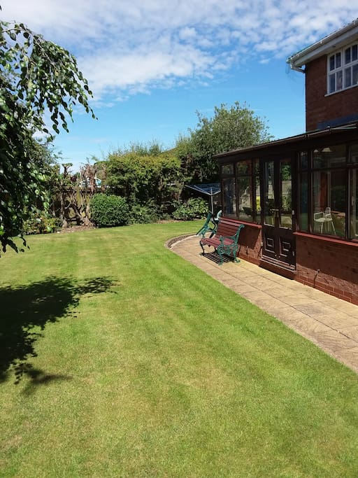 Large rear garden plus patio showing spacious conservatory