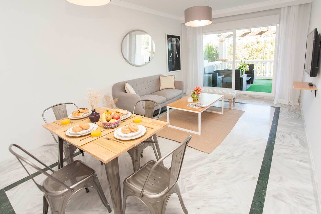 Modern living room, TV with international channels, comfortable sofas and indoor dining area.