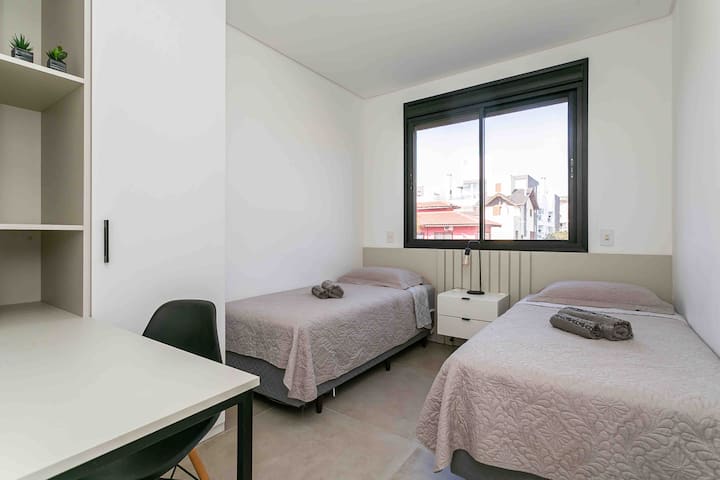 Habitación con dos camas individuales - ropa de cama - toallas - aire acondicionado dividido - apagón de persinaba - escritorio 
Armario con estante y cajones 