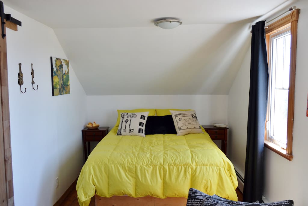 Chambre avec lit queen. Deux fenêtres avec vue sur la mer, la lagune et les dunes.