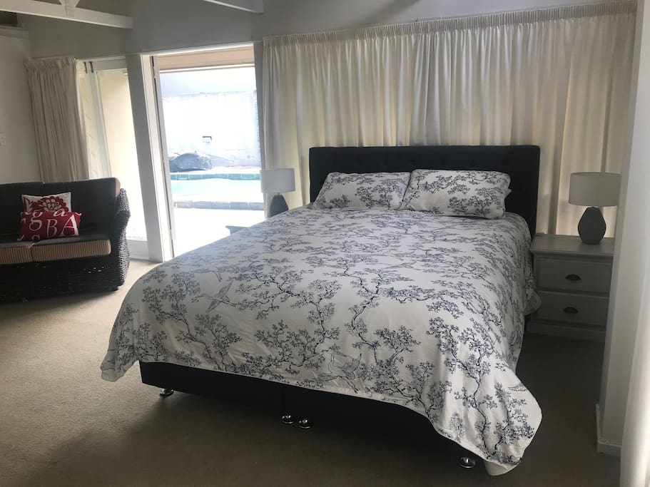 King sized bed by doors opening to pool
