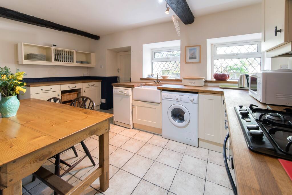 Dining/Kitchen with dining table and range of cream painted kitchen units.
