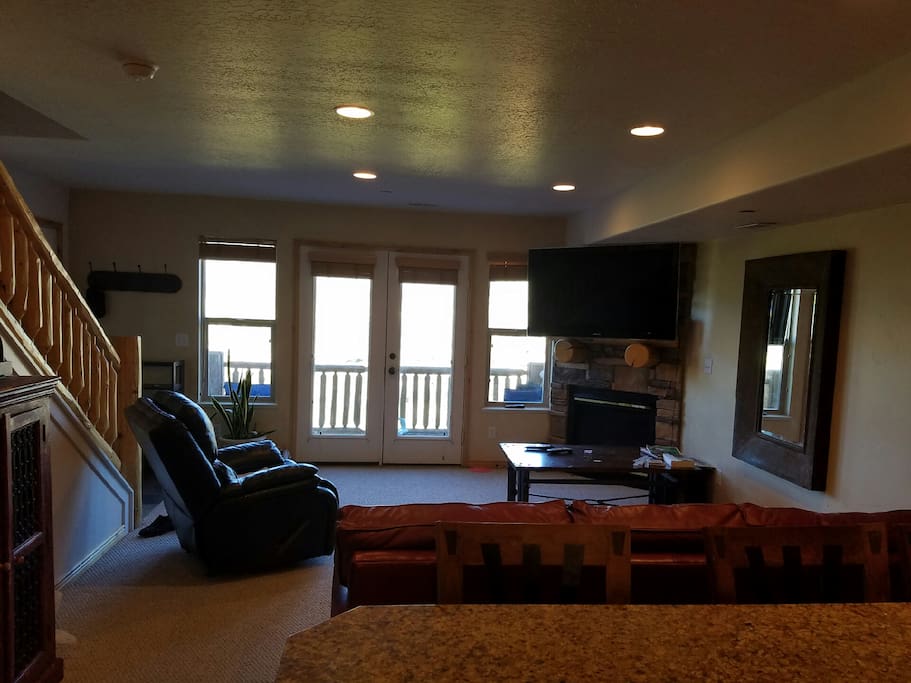 Living room with 55" HDTV, gas fireplace, and doors to one of the balconies