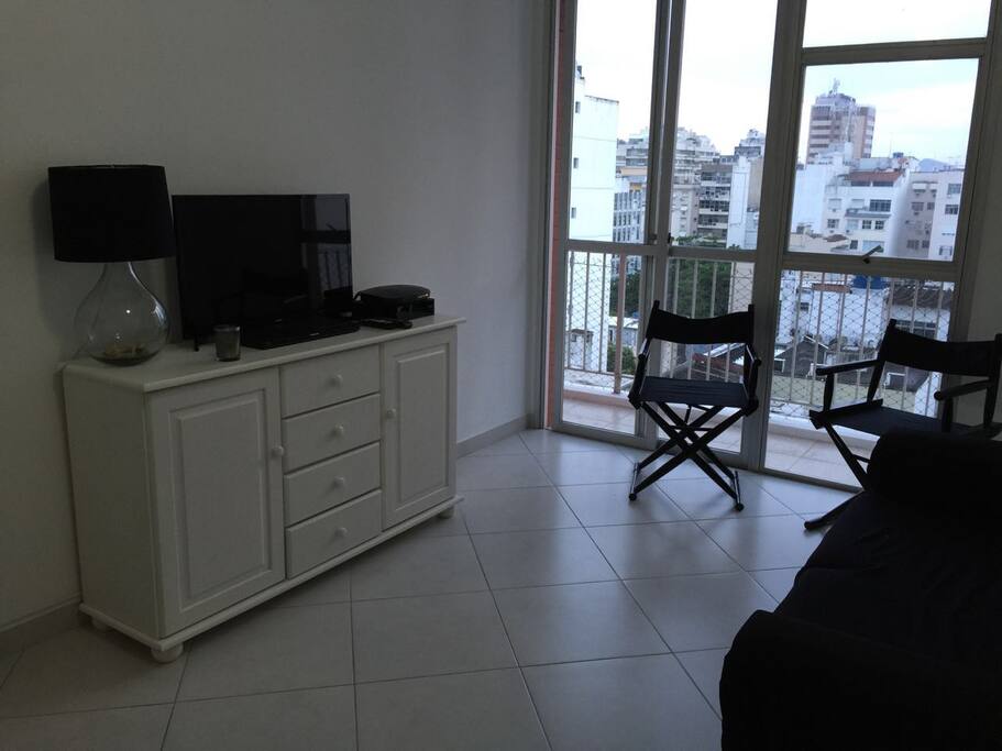 SALA COM TELEVISÃO, SOFÁ, CADEIRAS DECORATIVAS E MESA