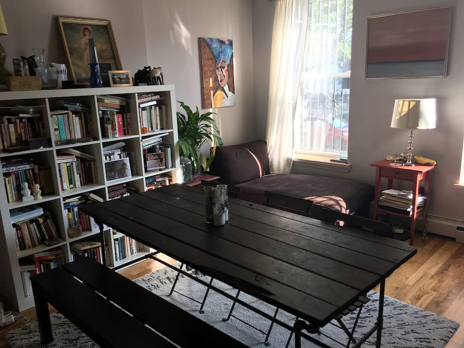 Living room with large dining room table and lots of light.