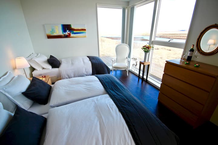 Bedroom 2  - 3 single beds. Blackout curtains, floor to ceiling windows  offering a truly captivating  river and mountain view.