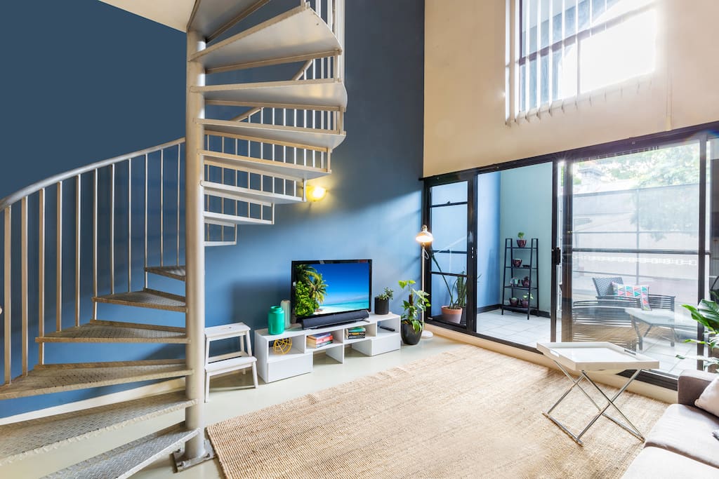 The living room with the steps to go upstairs to the bedroom and bathroom