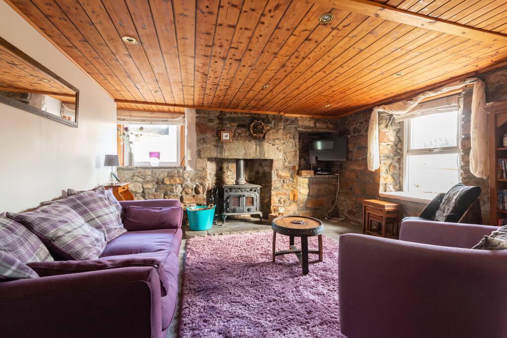Large cosy lounge with 2 sofas, more armchairs. Double woodburning stove, sky tv, dvd player, apple tv.