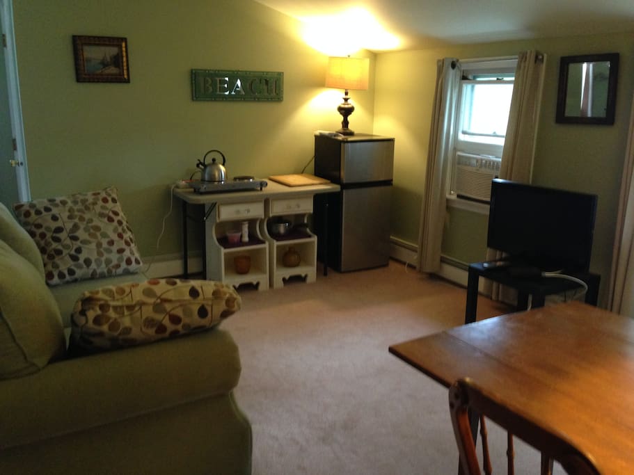 The living area: small refrigerator, desktop stove, Cable TV, window air conditioner, closets, dresser, dining table, glassware, and eating utensils. Refrigerator stocked with bottled water. There is also an extra queen bed in this room
