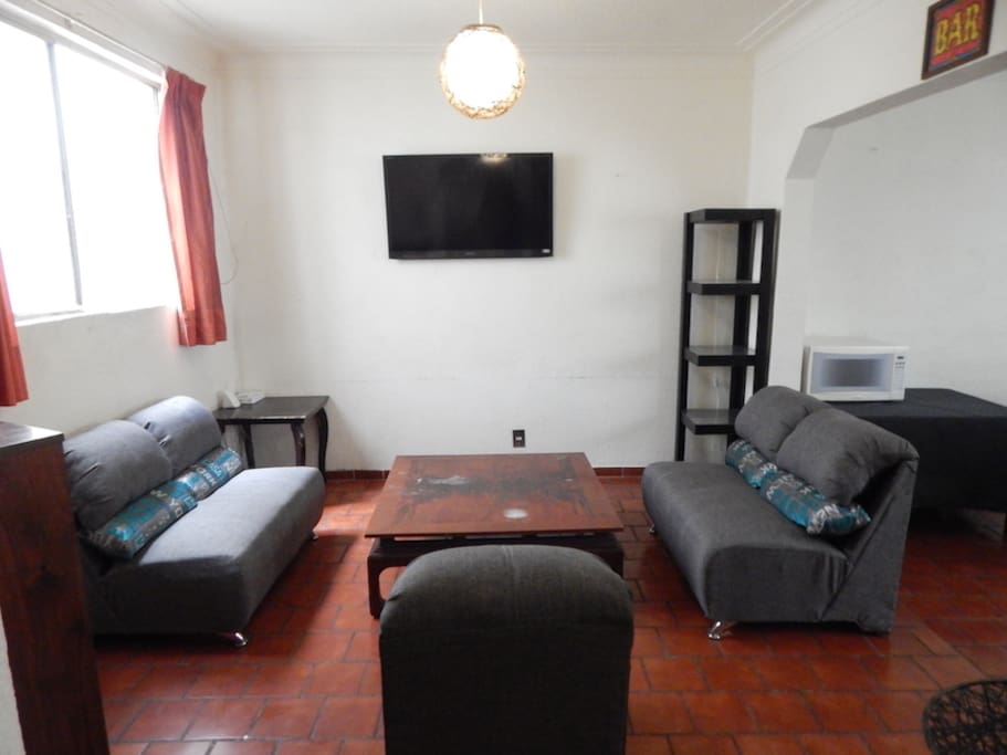 Sala con TV y radio vintage. / Living room with TV and vintage radio.