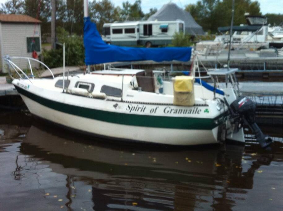 Docked with stored sails. Cabin entrance at back or stern/aft of boat.