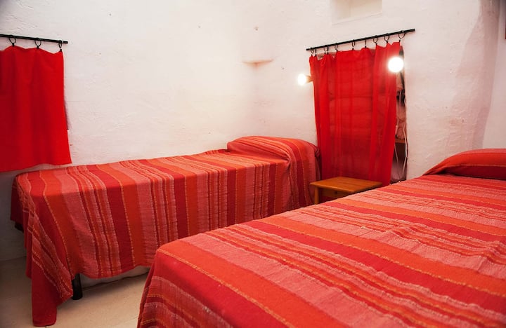 تتكون غرفة النوم 2 من سريرين فرديين. خلف الستائر الحمراء توجد مساحة للملابس والمتعلقات الشخصية.