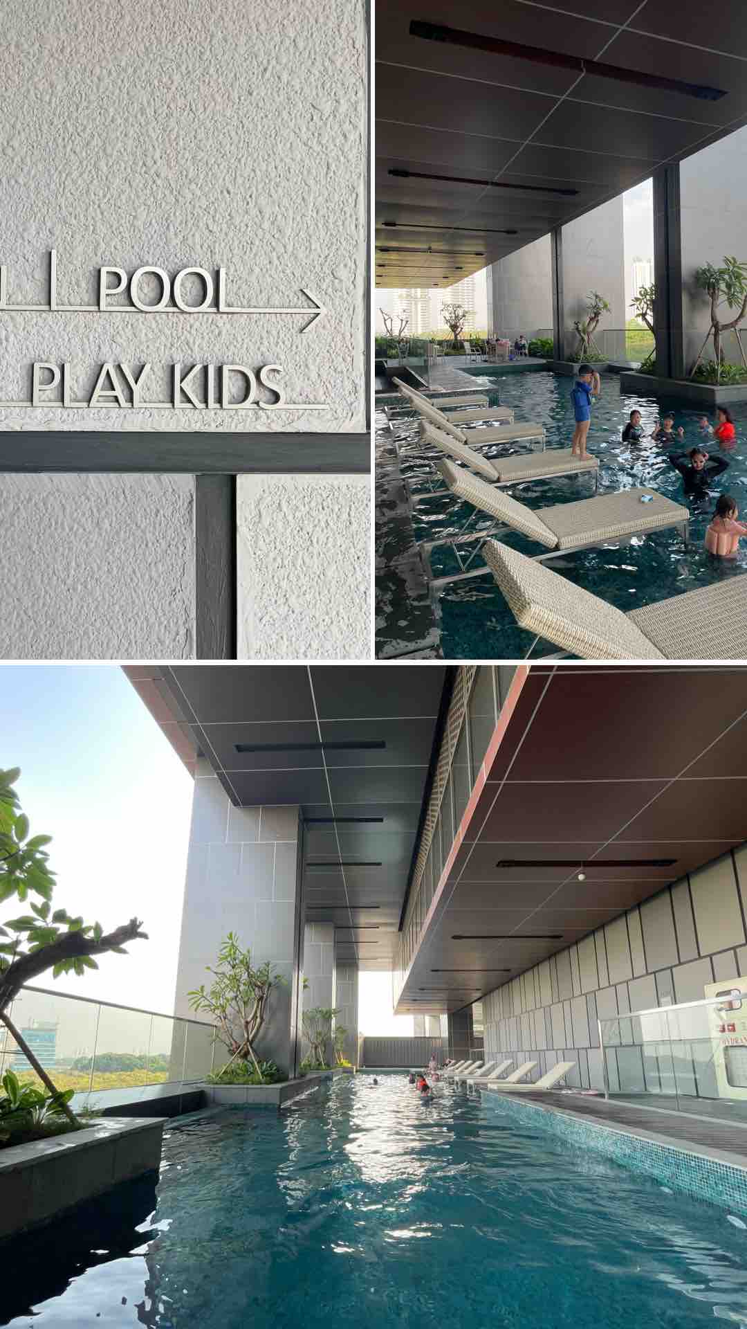 An indoor pool area features sleek gray tiles and comfortable lounge chairs. The space is well-lit, with plants offering a touch of greenery. Children can be seen enjoying the water, while clear windows allow natural light to illuminate the serene environment.