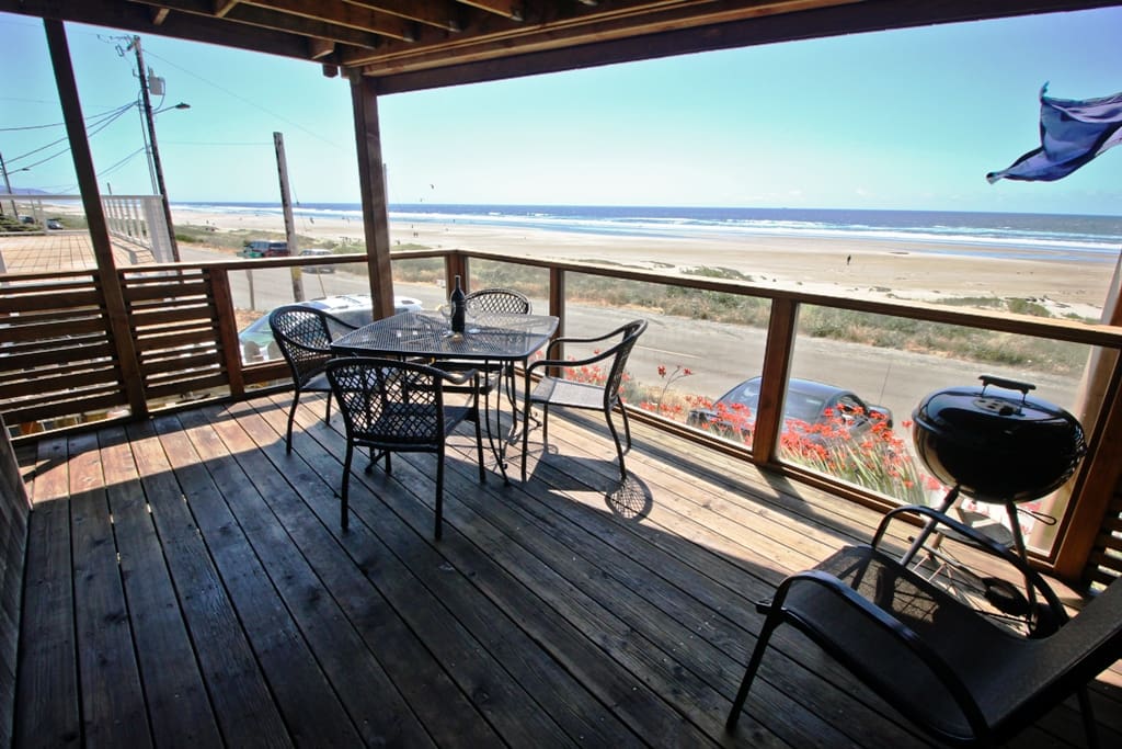 Lower covered, glassed deck with a patio table for 4, charcoal BBQ and spectacular coastal ocean views