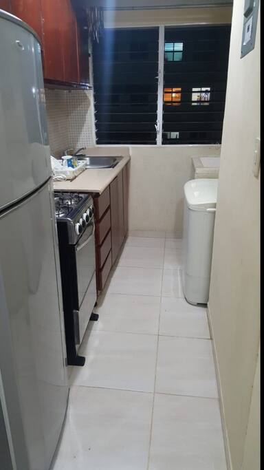 Cocina con estufa nevera fregadero y area de lavado con lavadero lavadora con secadora y tendedero