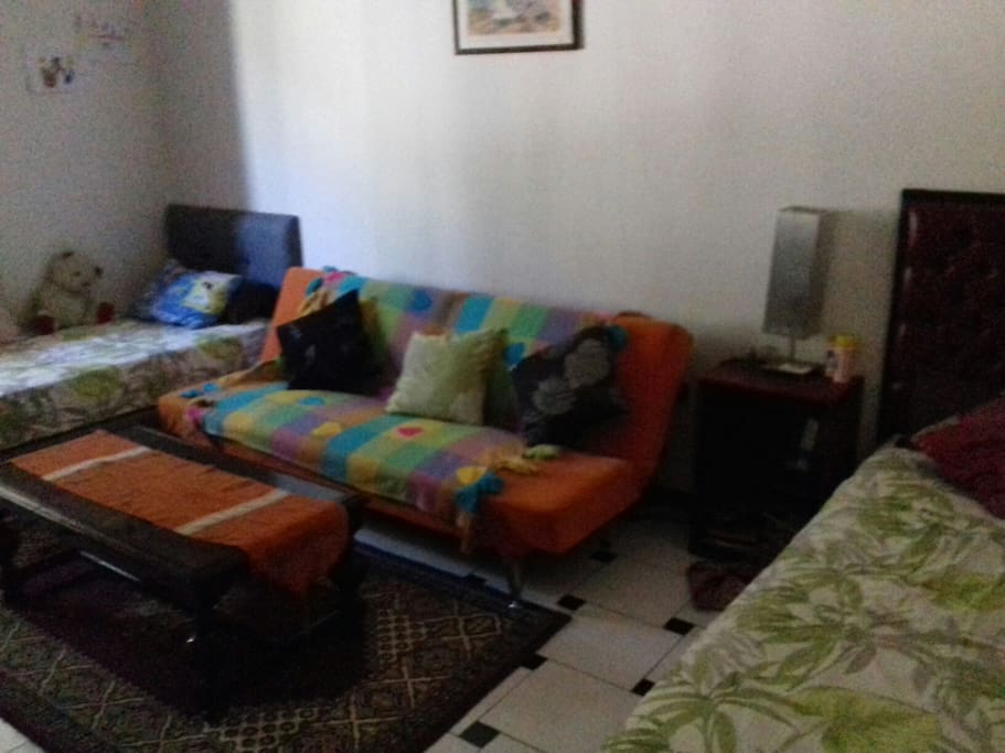 une chambre avec deux lit et un fauteuil lit avec veux aussi sur le jardin