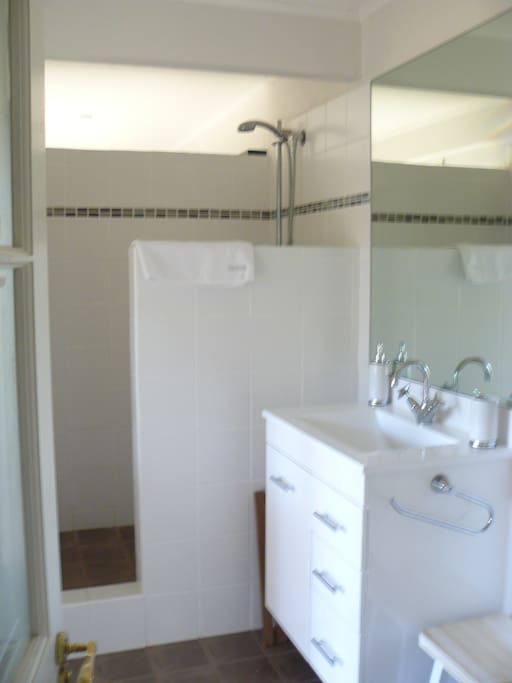 Clean and light bathroom with large mirror.