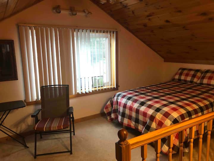 Cómodo dormitorio loft en el segundo piso con cama tamaño Queen