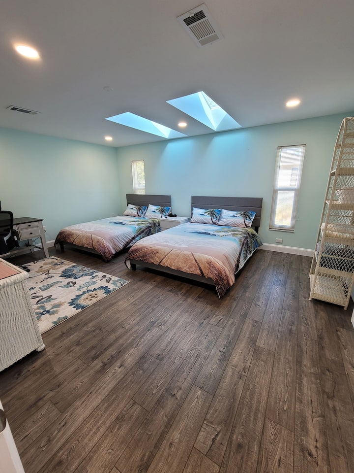 חדר שינה ענק עם שתי מיטות קווין סייז ועדיין שפע של מקום לשולחן בגודל מלא, טלוויזיה חכמה עם מסך שטוח גדול וארון כניסה!