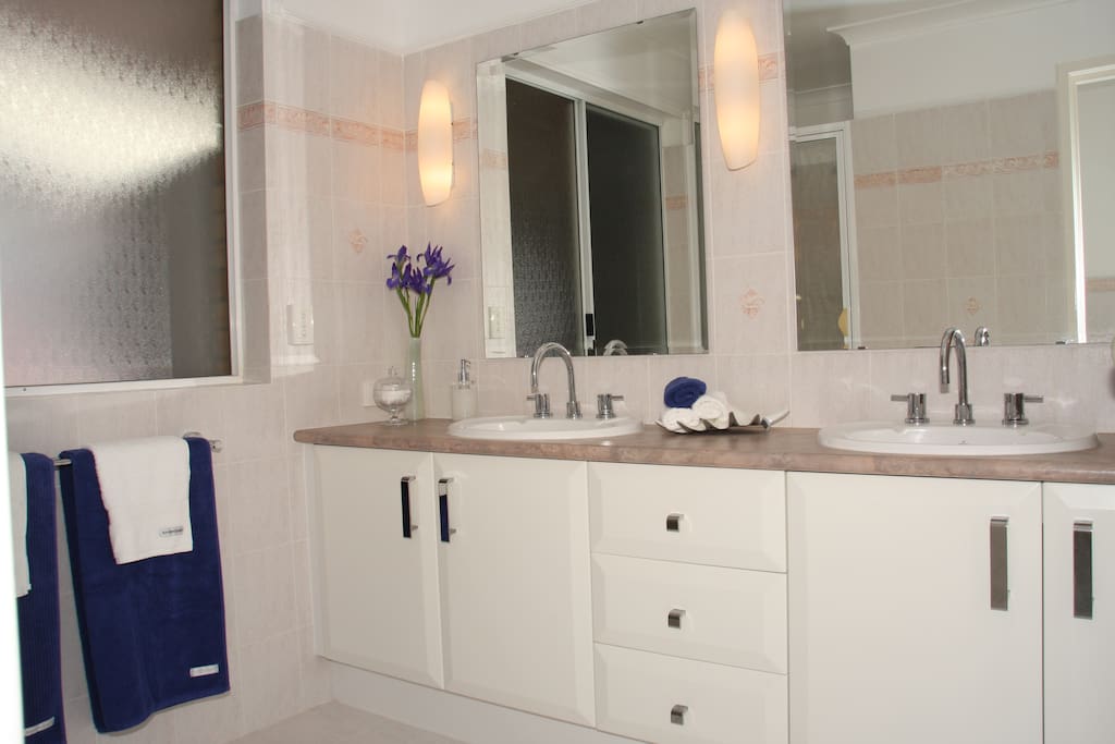 Large bathroom with double vanity, luxuriously soft towels, own shower, own toilet, weighing scales, soaps, shampoo, conditioner, hairdryer, hair straightener, make up mirror + more