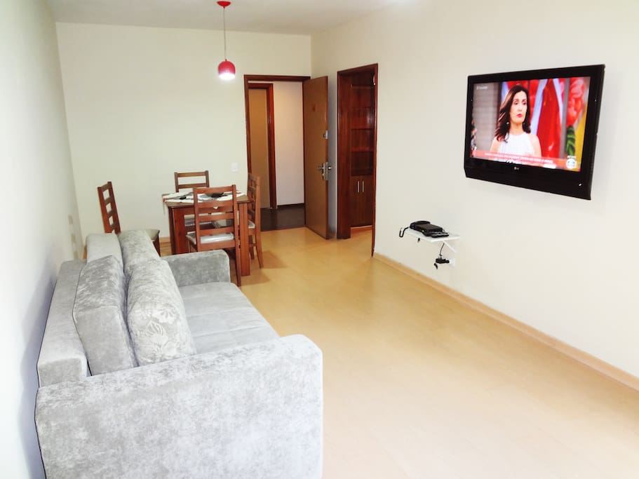 A spacious living room with a huge cable TV and an ar conditioning