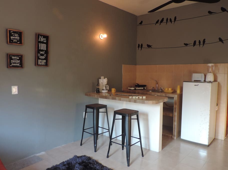 Cocina para realizar un desayuno relajante o jugar una partida de dominó con tu pareja o amigo. Refrigerador, cafetera, tostador, parrilla eléctrica, licuadora.