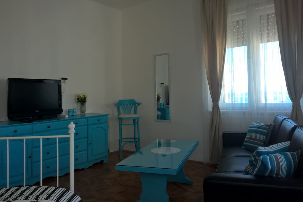 Also included in the room is a flat screen TV, a couch and a mirror.