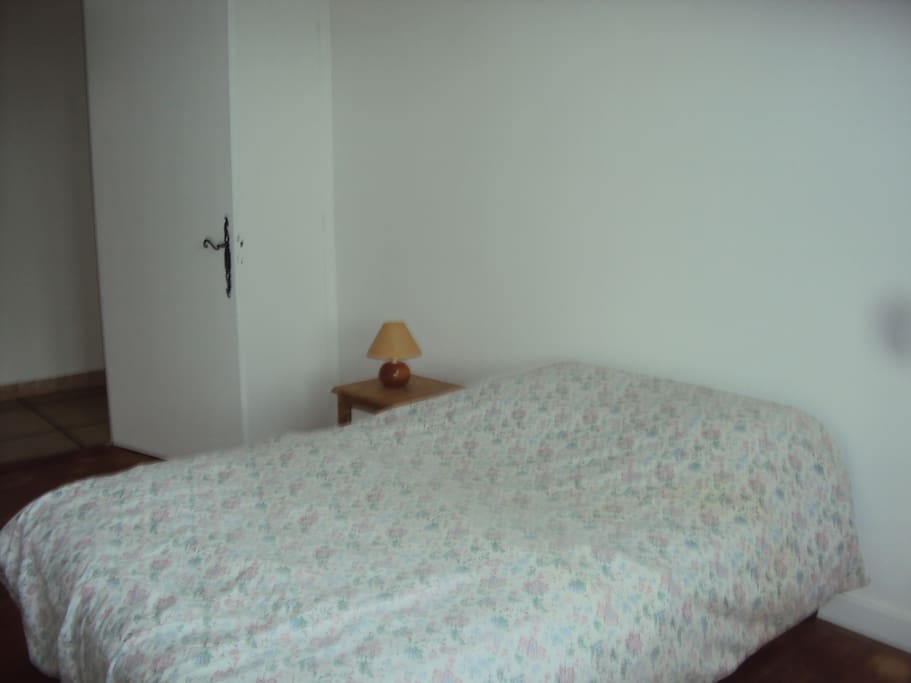Une chambre avec un lit deux places et un lit à une place orientée est.