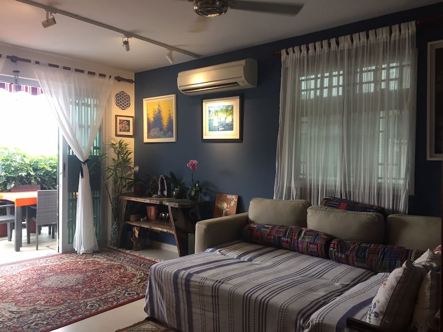 Spacious, bright living room with floor to ceiling glass windows open to terrace