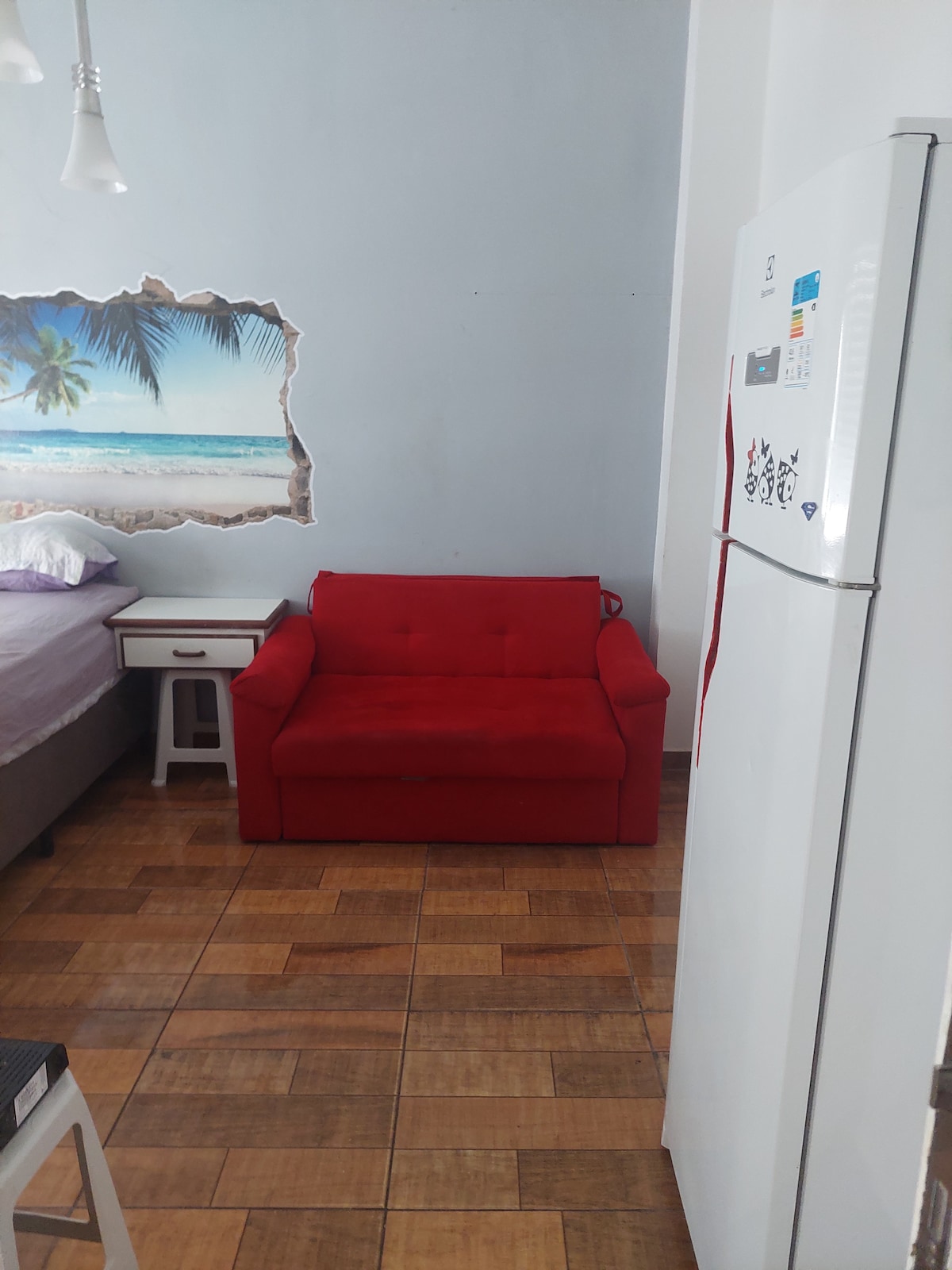 Sofá cama, cama doble y nevera de cocina.