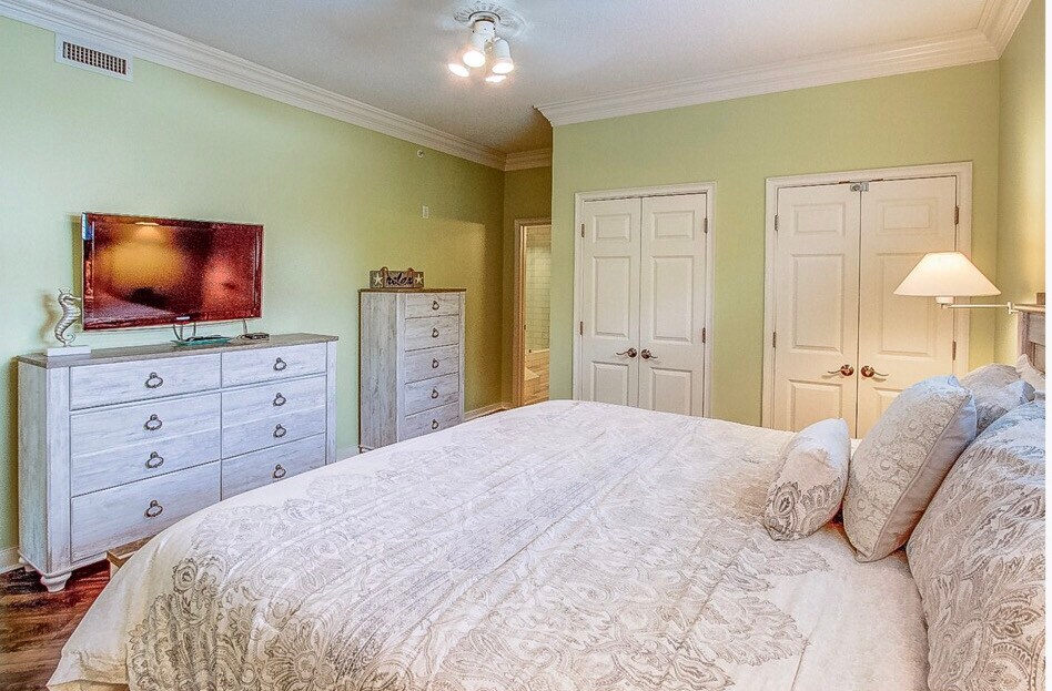 Comfortable king bed with TV in master bedroom.