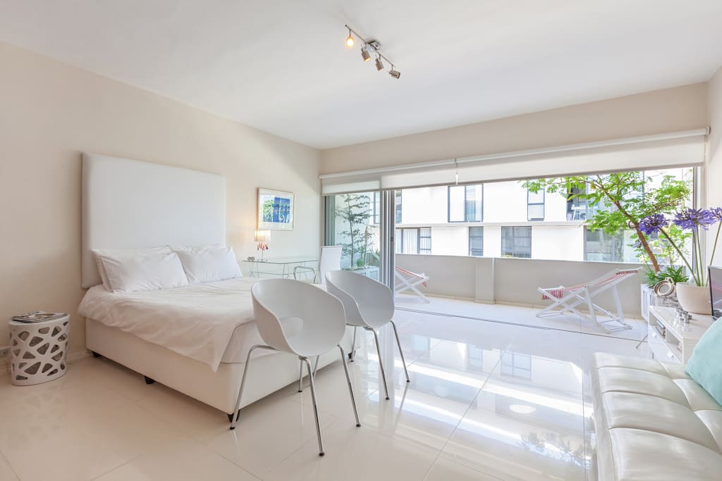 Open plan living and sleeping area, opening out to balcony