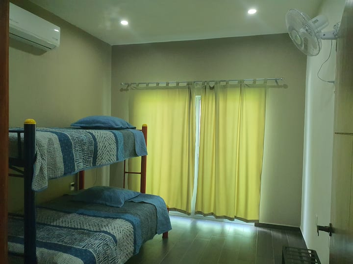 Chambre avec la climatisation et le chauffage. En outre, avec ventilateur mural, fixe ou rotatif. Fenêtre avec balcon. Lit superposé avec matelas double en bas et individuel en haut.