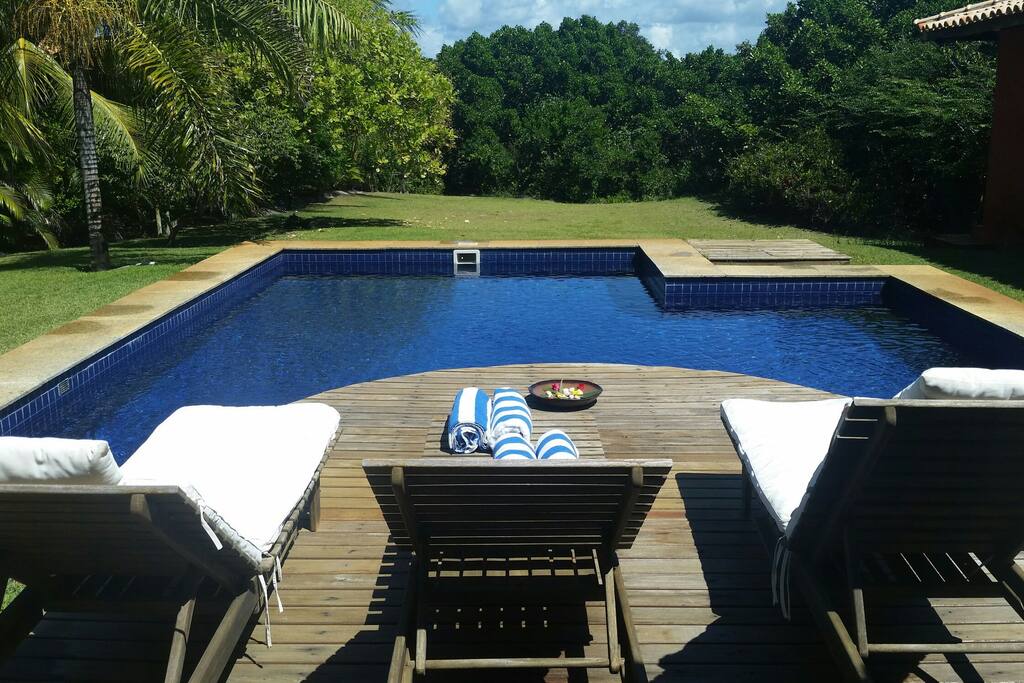 Piscina com toalhas e espreguiçadeira disponíveis.