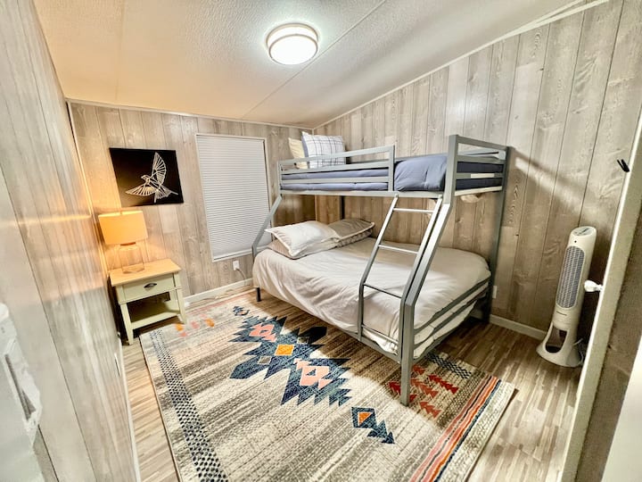 The Topo Chico room has a Twin over Full bunk bed with comfortable large rug, side table and embossed gold canvas. 
