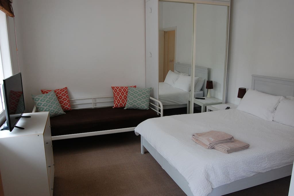 Spacious Main bedroom with spare day bed and plenty of cupboard storage.