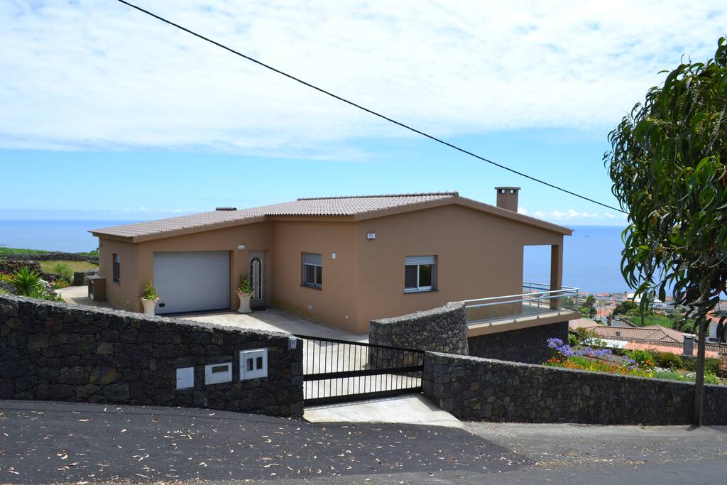 Casa vista de outro panorama, garagem, mar e jardim