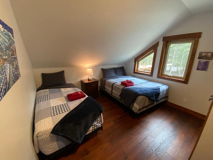 Twin bed and queen bed located upstairs. This cosy room has a closet to store luggage and a night stand.  Enjoy custom artwork and beautiful views of the Rocky's.