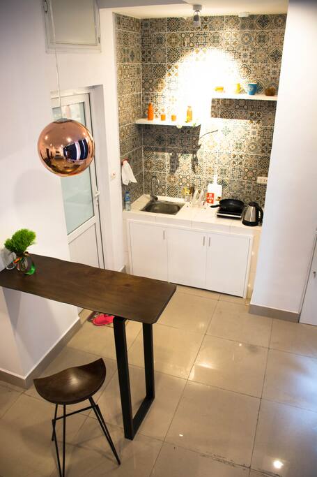 The kitchen furnished with fridge, induction cooker, tableware, electric kettle...
