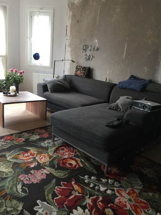 Bright living room with a cosy sofa and beamer.