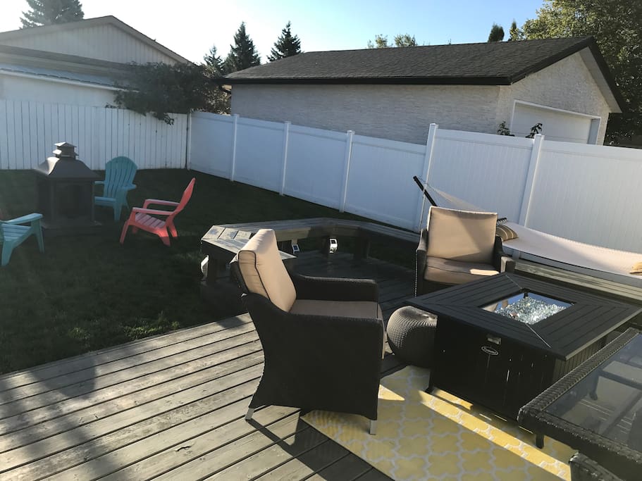 Back yard with fire pit, fire table and hammock. Tons of seating!