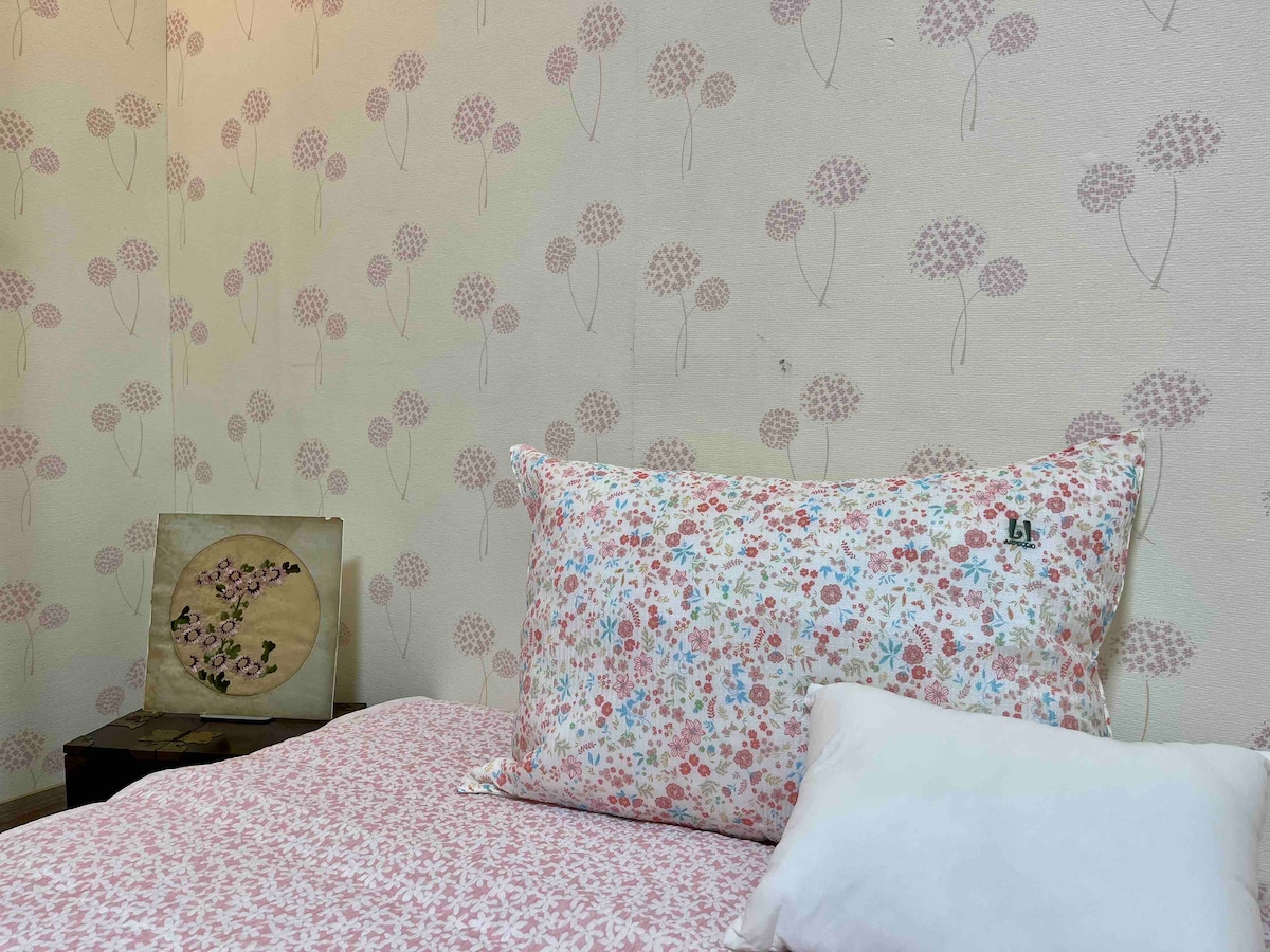 Спална соба бр. 102: постелнината и тапетите се обединети во розова боја.