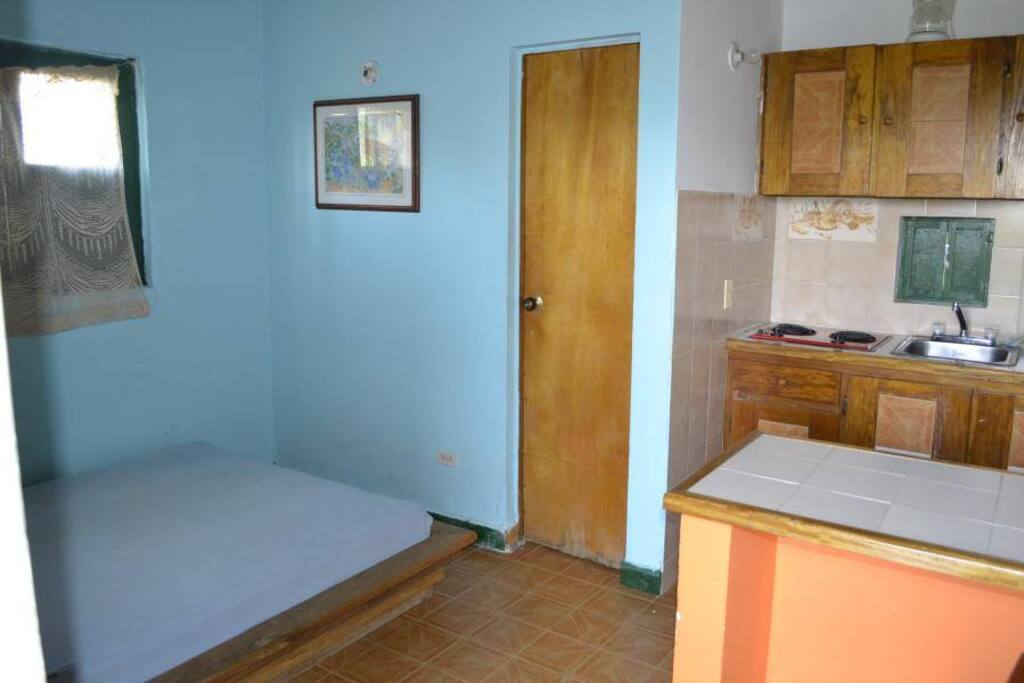Habitación con cama doble, baño privado con agua caliente y cocineta