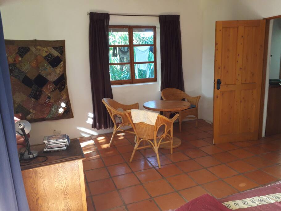 Small dining table with 4 chairs in Bedroom One. A two-seater sofa is also in this room
