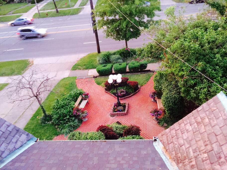 View of original slate roof over front porch and VIctorian courtyard with park benches from third floor. Bushes spell out the year the house was built 1900.