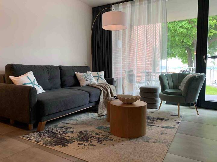 The living room with modern TV and fireplace to feel good. Everything is very soft and beautiful. The view on the water convinces anew every day;)