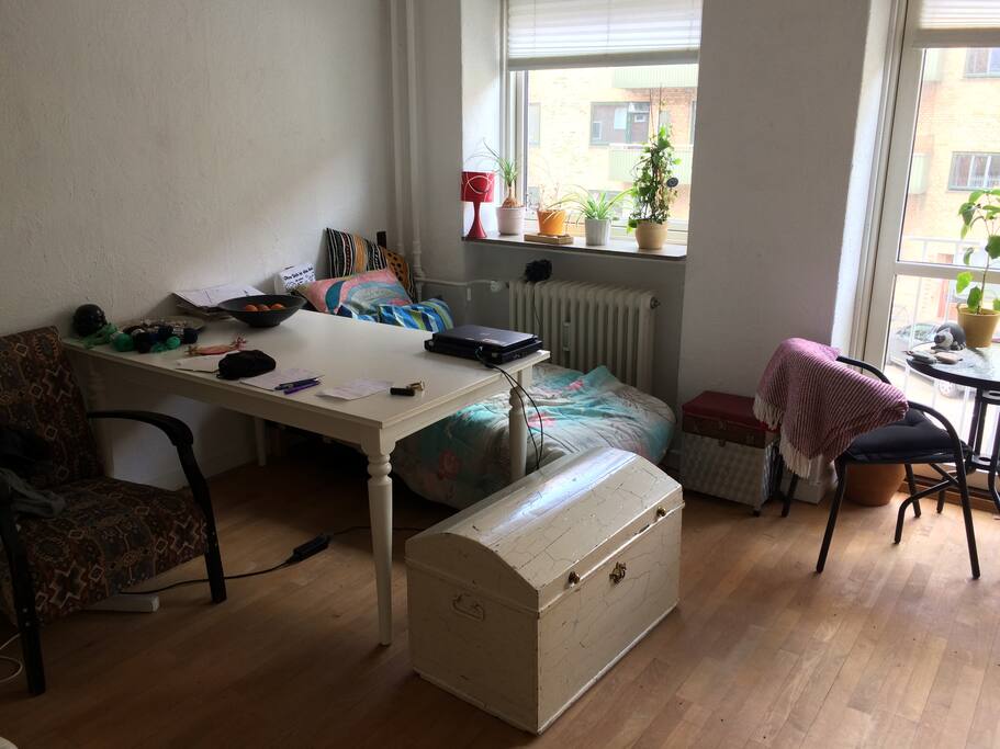 Stort spisebord, chaiselong og kiste, man kan sidde på.